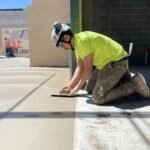 Masonry worker finishing a concrete floor on a construction site